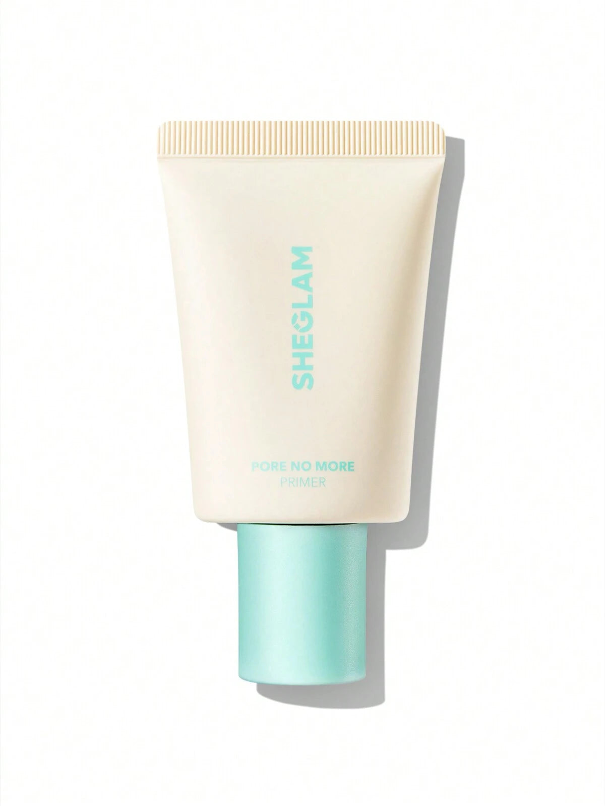 A tube of SHEGLAM Pore No More Primer with a beige body and green text, designed for achieving a flawless, shine-free look by minimizing pores and controlling oil.